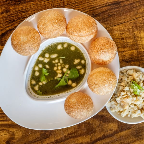 Maruti Indian Restaurant's pani puri with a bowl of green spiced water and a side of filling.